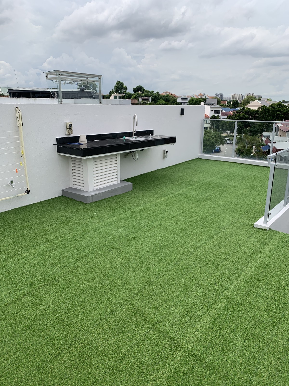Artificial grass rooftop deck with outdoor kitchen on a landed home in Singapore