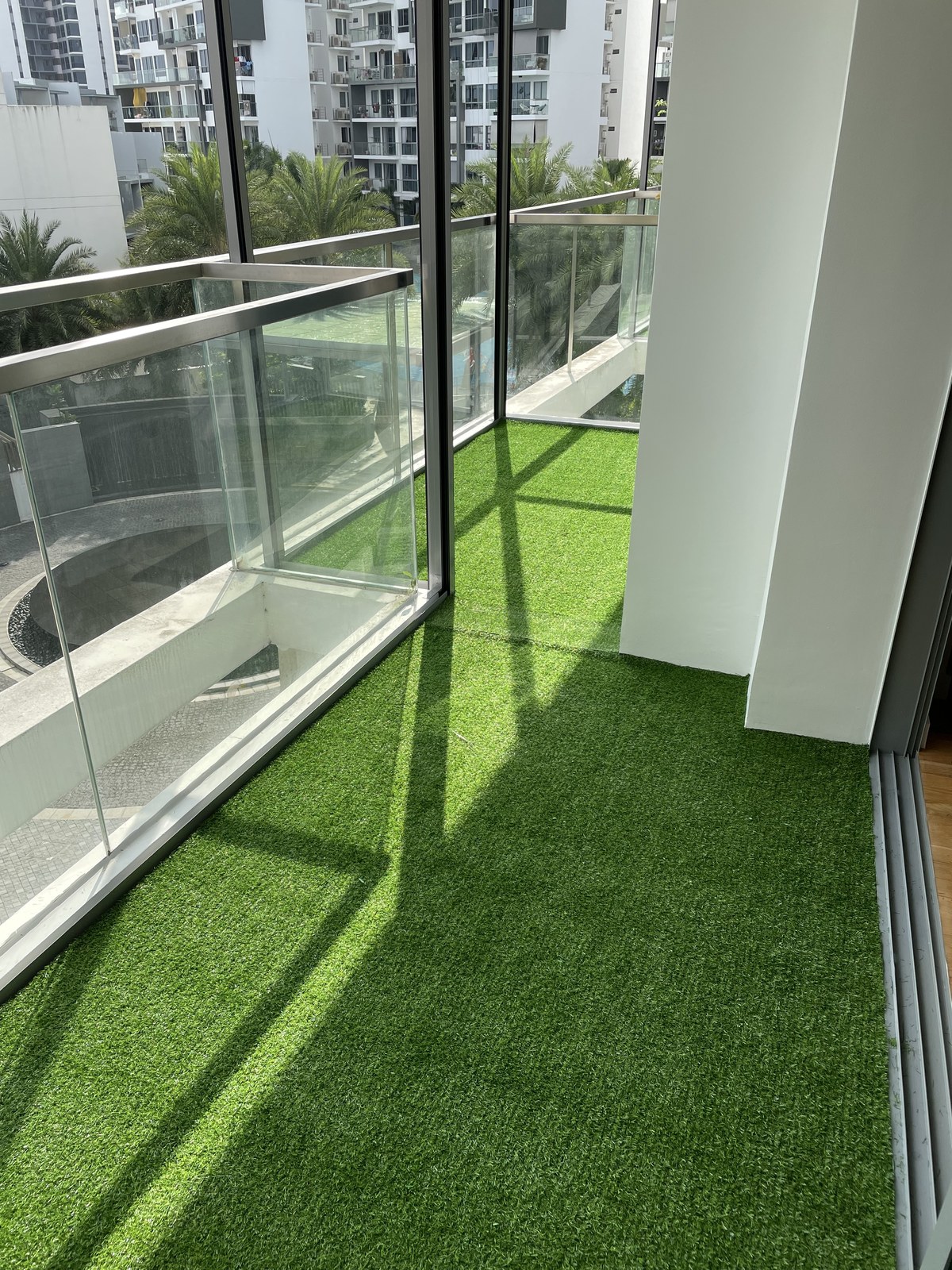 Condo balcony with artificial grass and a hanging egg chair
