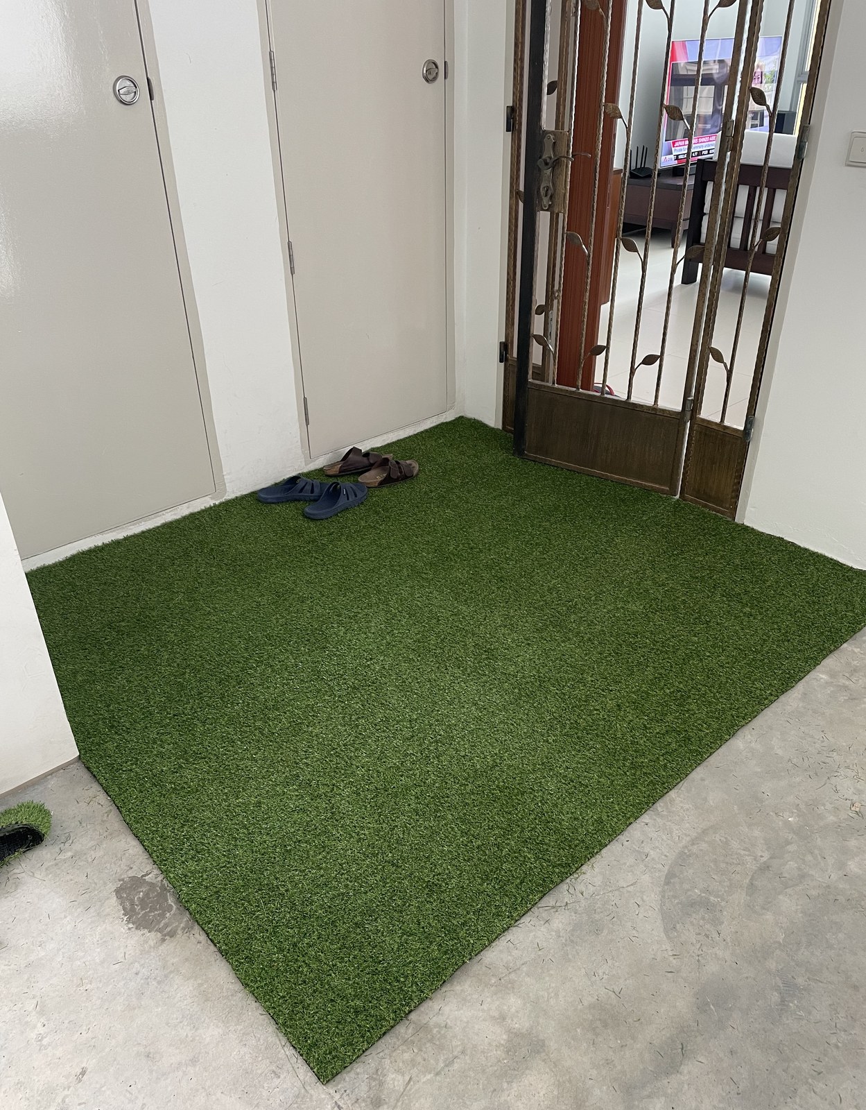 Artificial grass laid at an HDB door entrance in Singapore