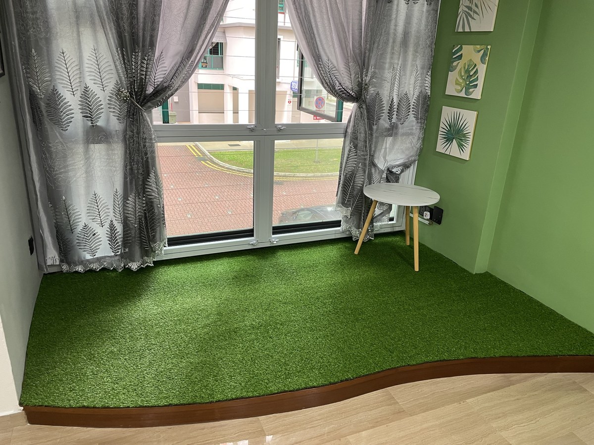Artificial grass used as an indoor accent corner by a window in an HDB flat
