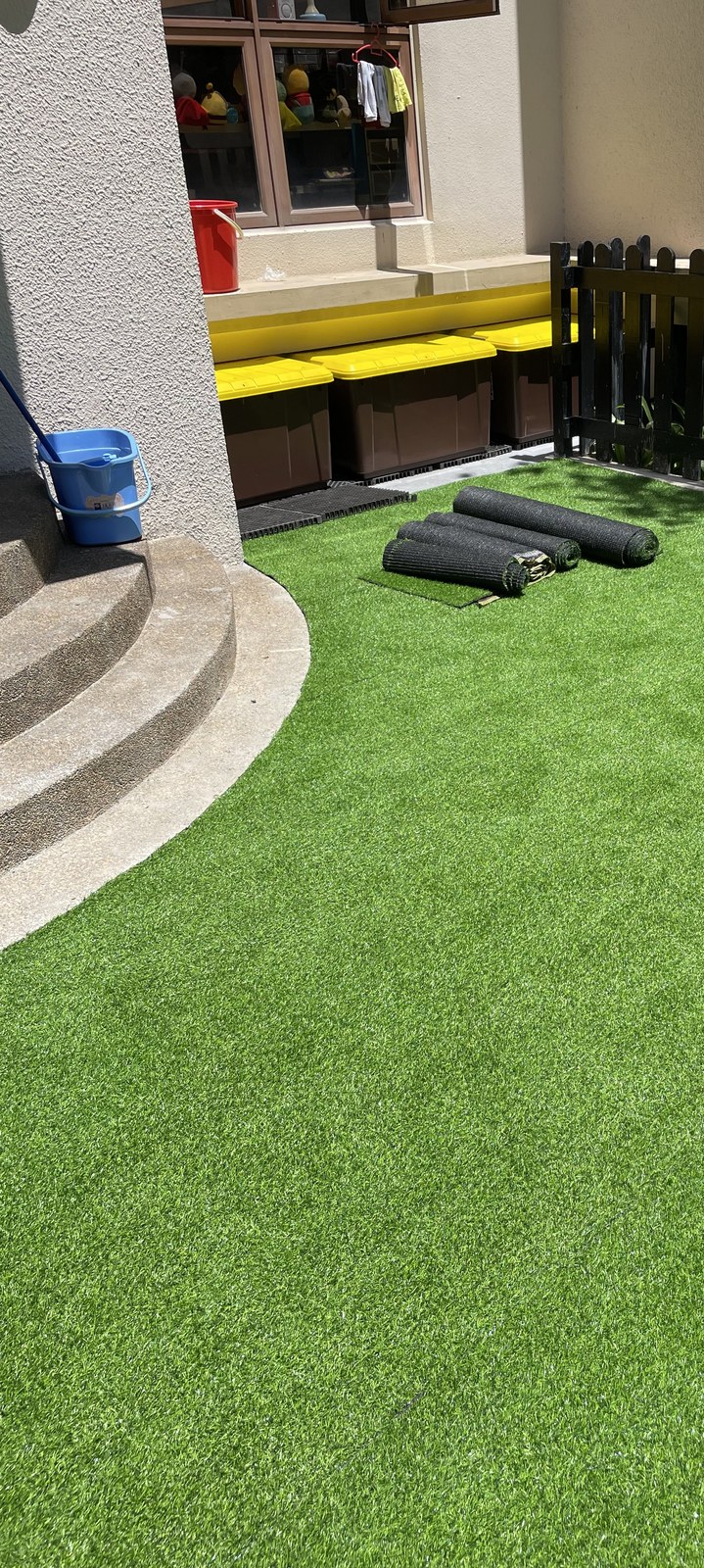 Indoor garden corner with artificial grass and a living wall accent