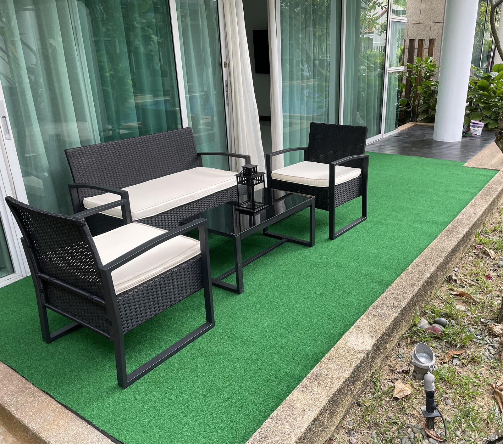 Condo patio with artificial grass and outdoor rattan furniture